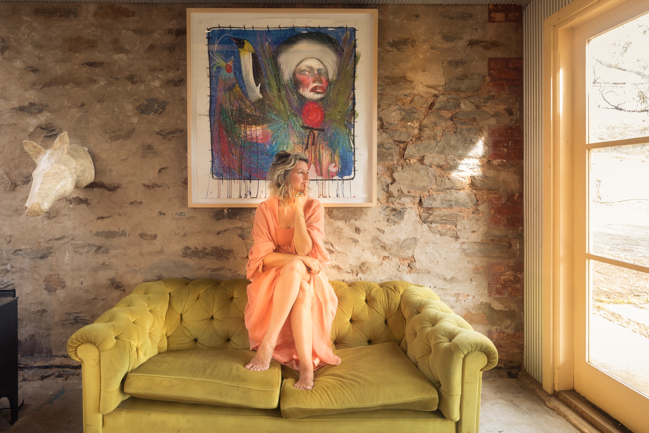 Mariana Mezic seated in her studio with her artwork